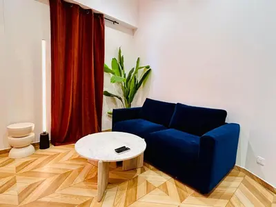 a living room with a blue couch and a table at Intimate Escape - Seaside - Spa Bath - WIFI - AC in Nice