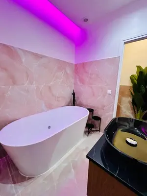 a white bath tub in a bathroom with a pink ceiling at Intimate Escape - Seaside - Spa Bath - WIFI - AC in Nice