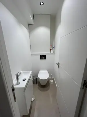 a white bathroom with a toilet and a sink at Port Lympia - Grand 2 Pièces Confort in Nice