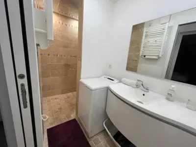 a white bathroom with a sink and a mirror at Port Lympia - Grand 2 Pièces Confort in Nice