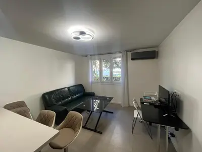 a living room with a couch and a table at Port Lympia - Grand 2 Pièces Confort in Nice