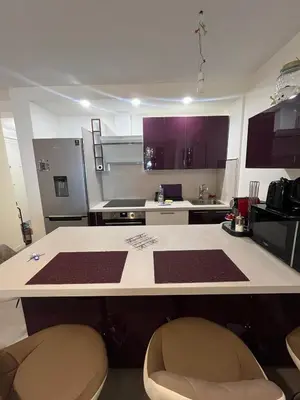 a kitchen with a counter and two chairs in it at Port Lympia - Grand 2 Pièces Confort in Nice