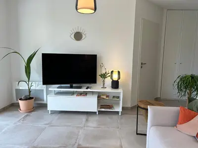 a living room with a flat screen tv on a white cabinet at L'Oasis Maritime By Avecoeur in Nice