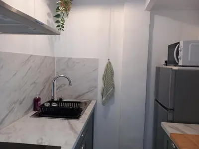 a kitchen counter with a sink and a refrigerator at Appartement cosy Nice in Nice