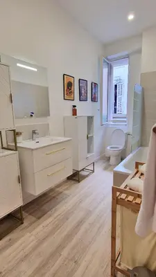 a white bathroom with a sink and a toilet at Jazzy et Spacieux Appartement Prom des Anglais in Nice
