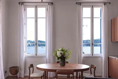 a dining room with a table with a vase of flowers at Blue House in Villefranche-sur-Mer