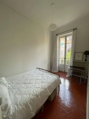 a bedroom with a white bed and a window at Blue House in Villefranche-sur-Mer