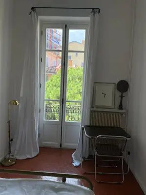 a bedroom with a bed and a large window at Blue House in Villefranche-sur-Mer