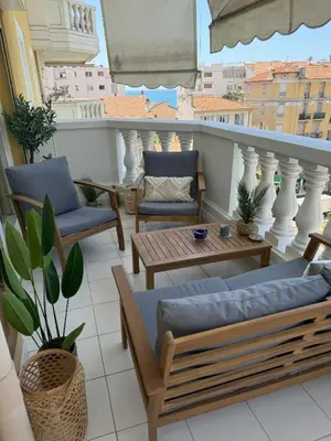 a balcony with couches and a table and chairs at Elegant Apartment with Sea View and Swimming pool in Nice