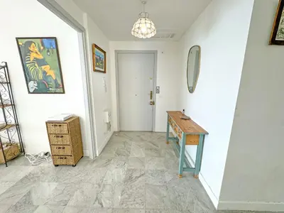 a hallway with a table and a mirror on the wall at Milord Promenade 4 in Nice