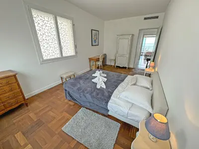 a bedroom with a large bed and a wooden floor at Milord Promenade 4 in Nice