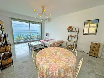 a living room with a table and a view of the ocean at Milord Promenade 4 in Nice
