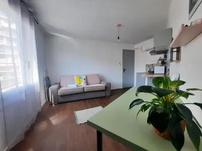a living room with a couch and a table at La Chambre 3, Climatisée AC, Cuisine privée, Calme in Nice