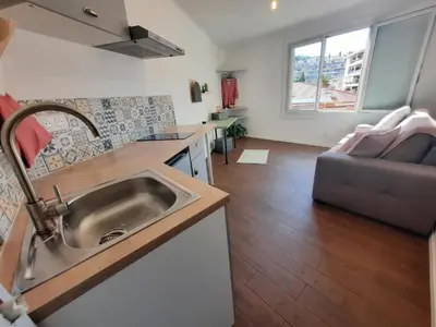 a kitchen with a sink and a living room with a couch at La Chambre 3, Climatisée AC, Cuisine privée, Calme in Nice