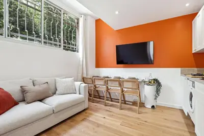 a living room with a couch and an orange wall at Lavie Maison Hot Tub Seaside Flat in Nice