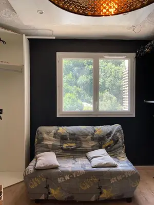a couch sitting in a room with a window at appartement idéalement situé in La Trinité