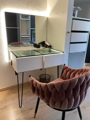 a dressing table and a chair with a mirror at appartement idéalement situé in La Trinité