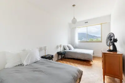 a white bedroom with a bed and a window at Happyfew Le Floreal in Nice