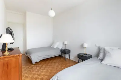 a bedroom with two beds and a dresser with two lamps at Happyfew Le Floreal in Nice