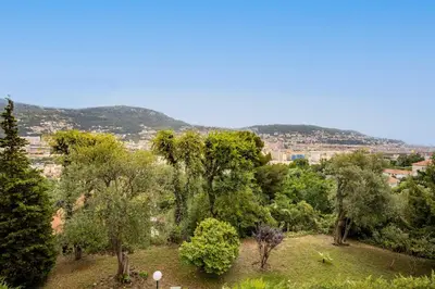 a group of trees with a city in the background at Happyfew Le Floreal in Nice