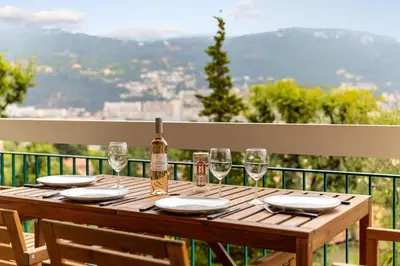 a wooden table with glasses and a bottle of wine at Happyfew Le Floreal in Nice