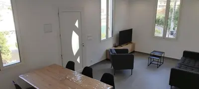 a room with a table and chairs and a television at Appartement 4 p neuf dans haut de villa , clim, parking, jardin in Saint-Laurent-du-Var
