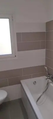 a bathroom with a tub and a sink and a window at Appartement 4 p neuf dans haut de villa , clim, parking, jardin in Saint-Laurent-du-Var