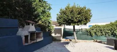 a yard with a tree and a table and a building at Appartement 4 p neuf dans haut de villa , clim, parking, jardin in Saint-Laurent-du-Var