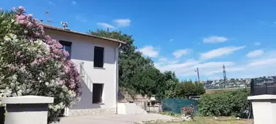 a white house with flowers on the side of it at Appartement 4 p neuf dans haut de villa , clim, parking, jardin in Saint-Laurent-du-Var