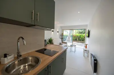 a kitchen with a sink and a large window at Studio idéalement situé résidence front de mer in Saint-Laurent-du-Var