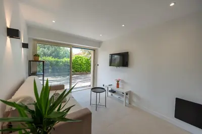 a living room with a couch and a tv at Studio idéalement situé résidence front de mer in Saint-Laurent-du-Var