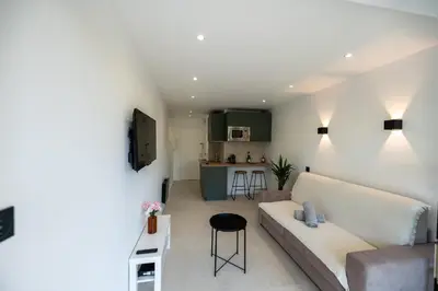 a living room with a couch and a kitchen at Studio idéalement situé résidence front de mer in Saint-Laurent-du-Var