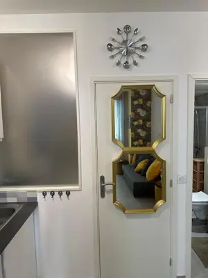 a kitchen with a door with a mirror and a couch at Studio Coeur Delille FSHH in Nice