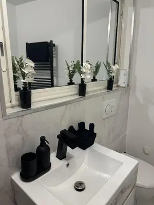 a white bathroom with a sink and a mirror at Jolie deux pièces au cœur de Nice in Nice