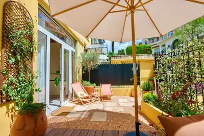 a patio with two chairs and an umbrella at Nice - Amazing flat to 10 min to sea - Garden in Nice