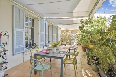 a patio with a table and chairs and plants at Luxueux appartement avec terrasse et parking in Nice