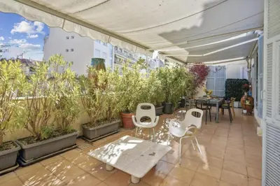 a patio with white chairs and tables and plants at Luxueux appartement avec terrasse et parking in Nice