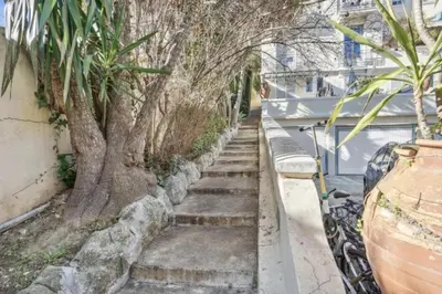 a stairway with a tree next to a building at Luxueux appartement avec terrasse et parking in Nice