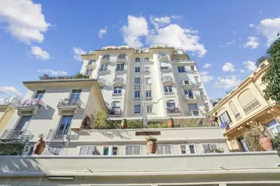 a large white building with potted plants in front of it at Luxueux appartement avec terrasse et parking in Nice