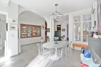 a white dining room with a table and chairs at Luxueux appartement avec terrasse et parking in Nice