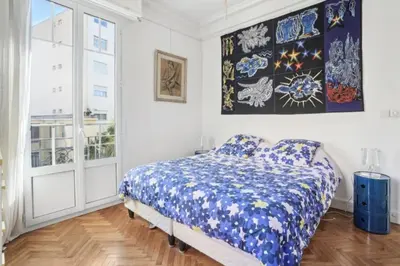 a bedroom with a bed and a large window at Luxueux appartement avec terrasse et parking in Nice