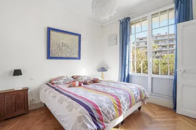 a bedroom with a bed and a large window at Luxueux appartement avec terrasse et parking in Nice