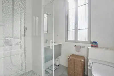 a white bathroom with a shower and a sink at Luxueux appartement avec terrasse et parking in Nice