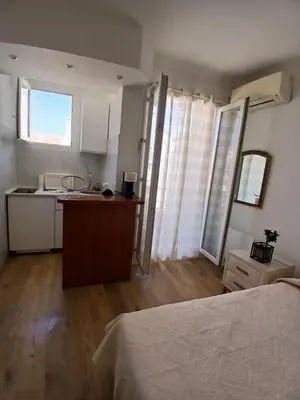 a bedroom with a bed and a kitchen with a counter at Maria in Nice