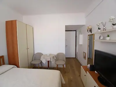 a bedroom with a bed and two chairs and a television at Maria in Nice