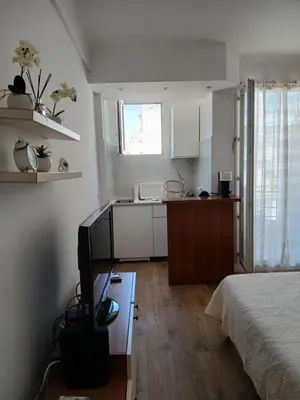 a room with a bed and a kitchen with a television at Maria in Nice