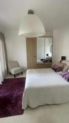 a bedroom with a large white bed and a mirror at face à la mer in Cros-de-Cagnes