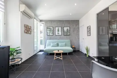 a living room with a blue couch and a table at Large & Quiet 1 Bdr at Nice Port in Nice