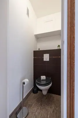 a bathroom with a toilet with a black wall at Open Sky Terrace Lage 1 Bdr & Parking in Nice