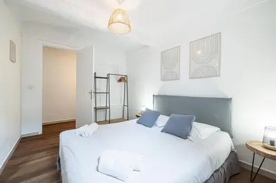 a bedroom with a large white bed with blue pillows at 2 Bdr Heart of the Old Town in Nice